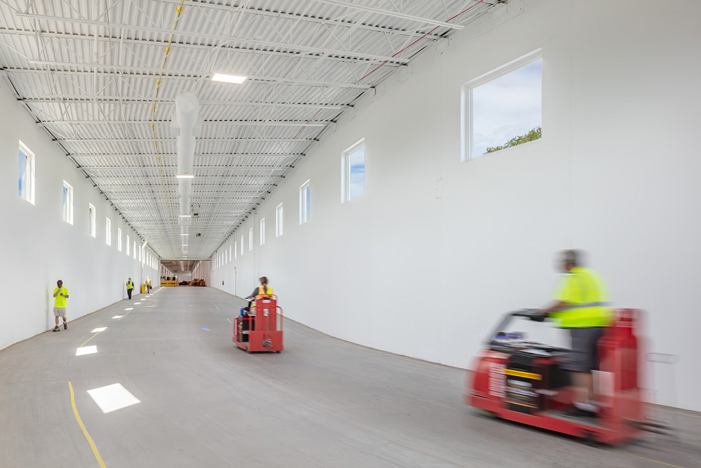 warehouse in an industrial building with people walking and driving equipment