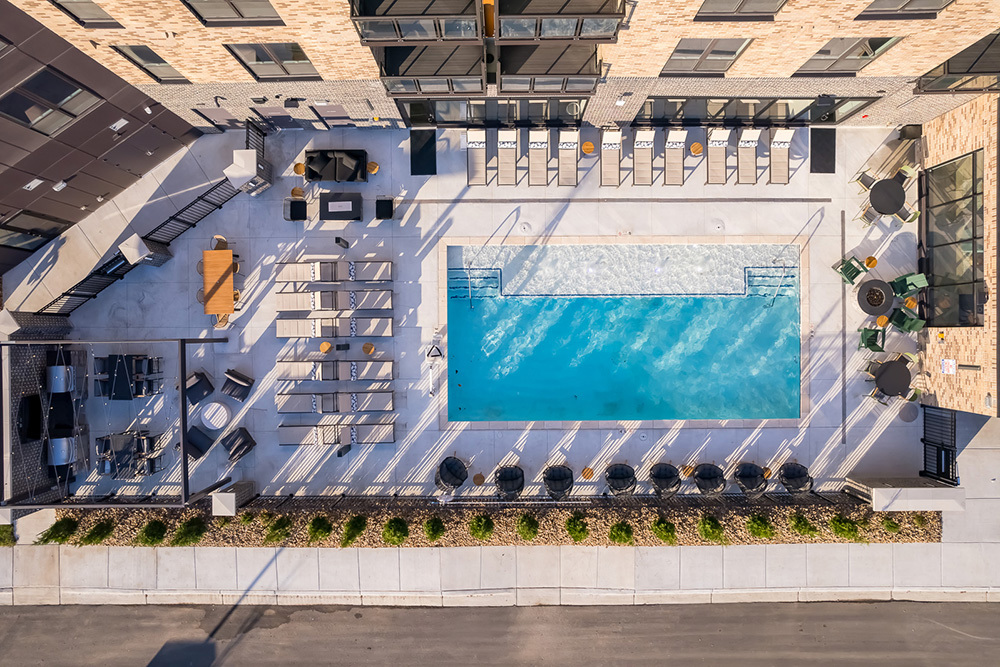 aerial view of an apartment building's outdoor amenity area including pool