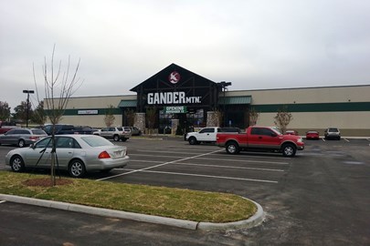 exterior of the entrance of a Gander Mtn. retail store with parking lot in foreground