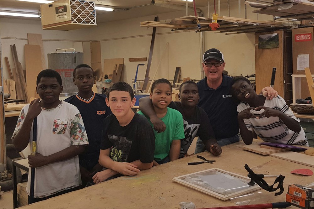 man with group of boys in carpentry classroom