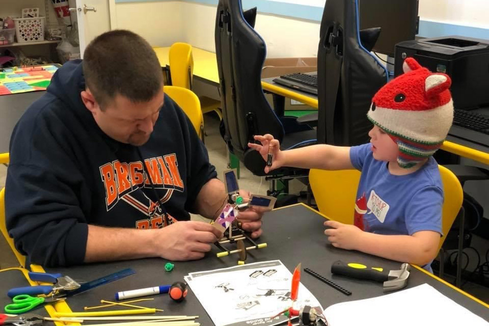 man and child building robotics