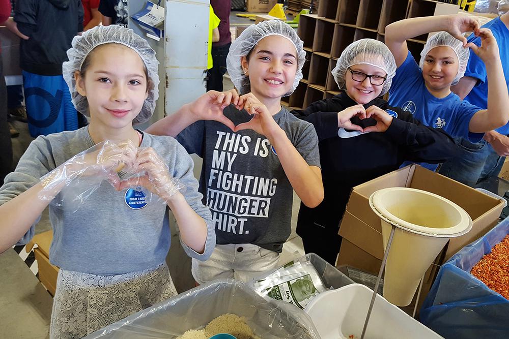 children packing food at Meals from the Heartland