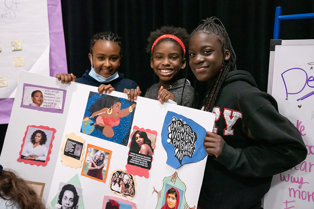 three girls holding poster project at Denver Kids