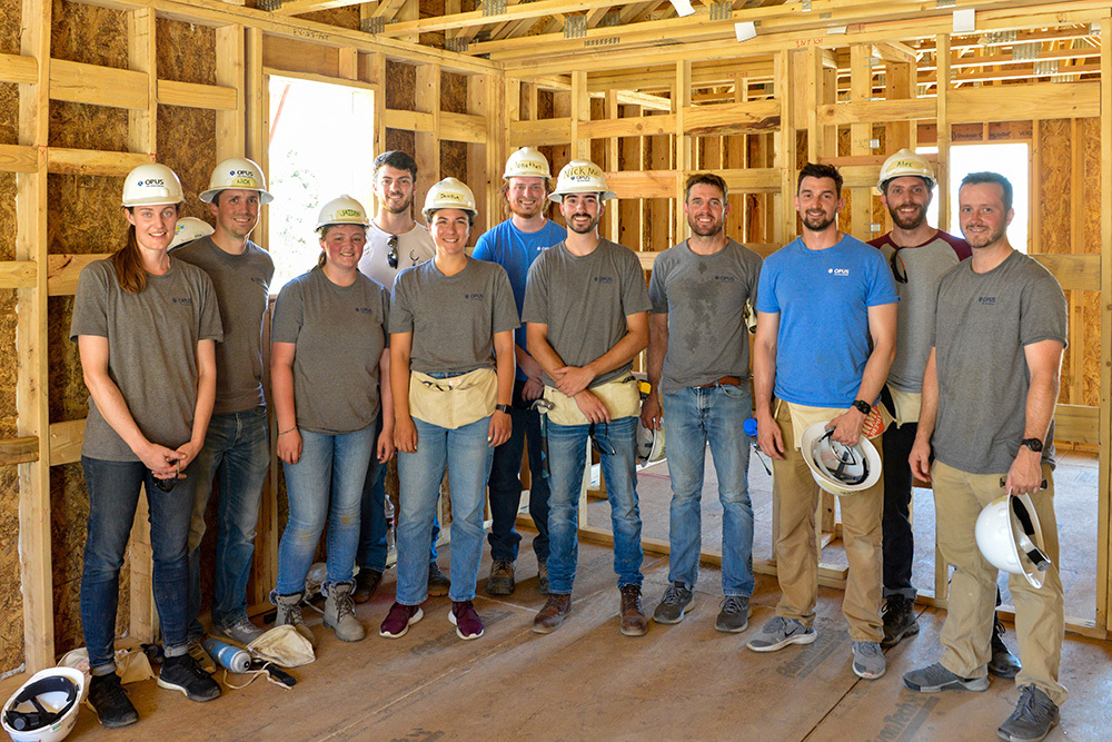 Group of men and women with helmets in house under construction