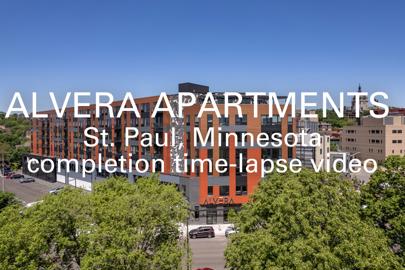 words "Alvera Apartments, St. Paul, Minnesota, completion time-lapse video" written in foreground with exterior of residential apartment building in background