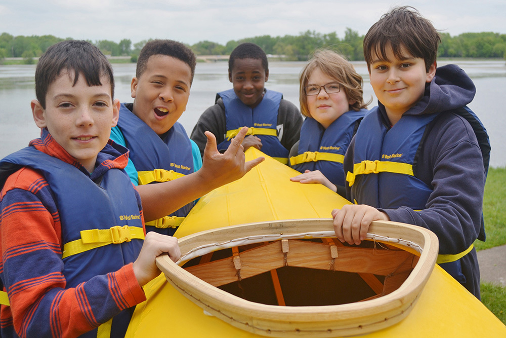 boys holding canoe
