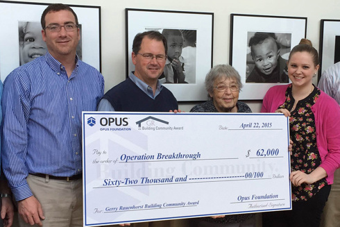 smiling men and women holding a large check during a check presentation