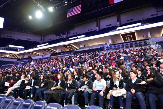 students sitting in indoor stadium