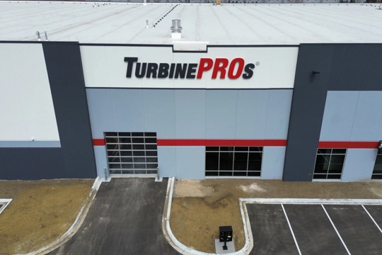 drone view of exterior of industrial building with sign reading "TurbinePROs"