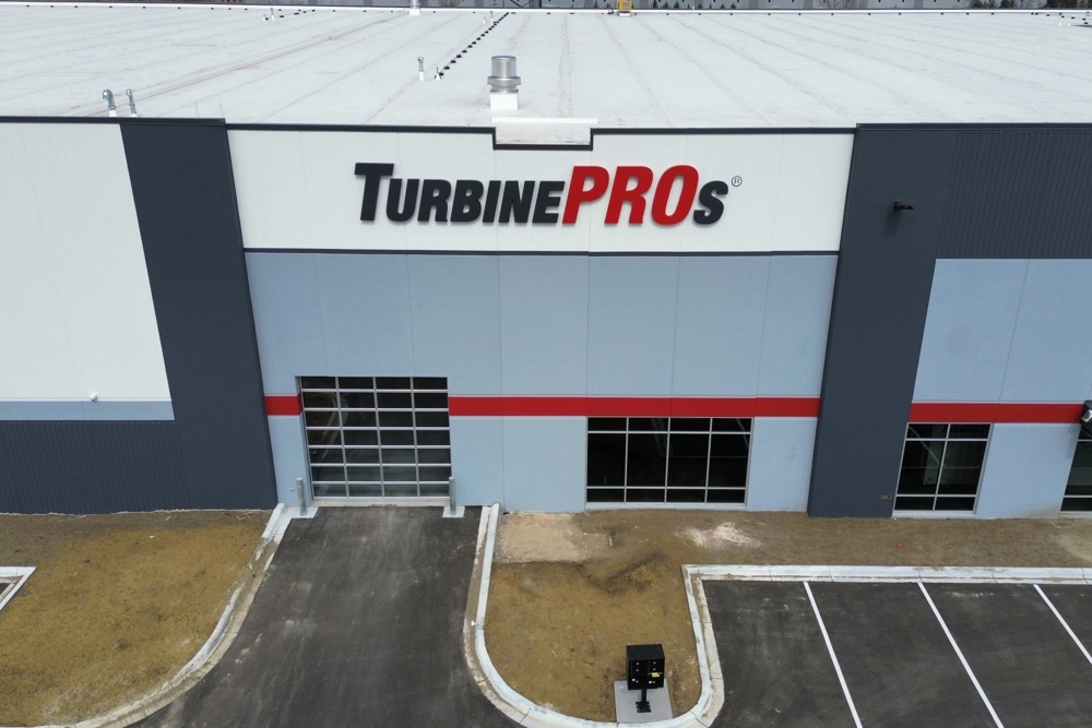 drone view of exterior of industrial building with sign reading "TurbinePROs"