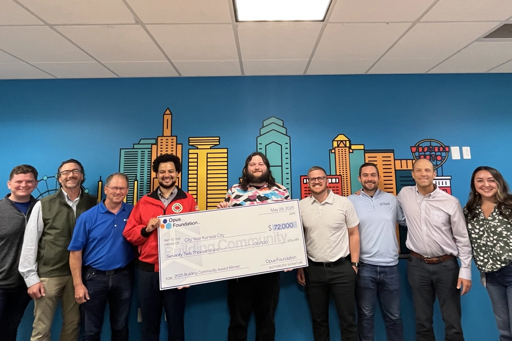 group of men and women holding a large check
