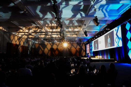event area with stage on right and shadows and colorful lights reflecting on ceiling and walls