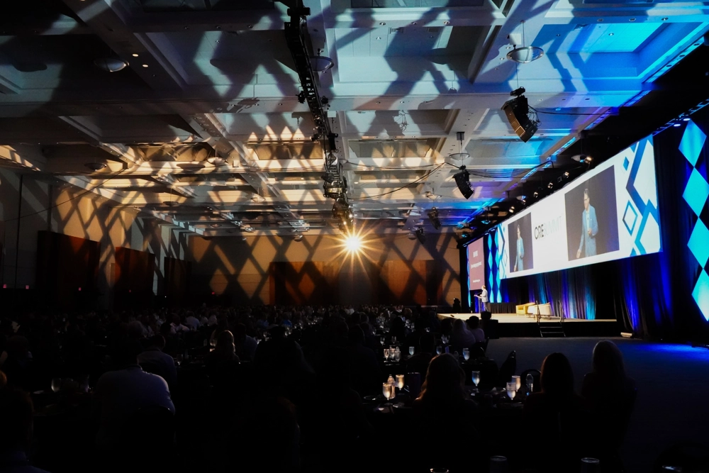 event area with stage on right and shadows and colorful lights reflecting on ceiling and walls