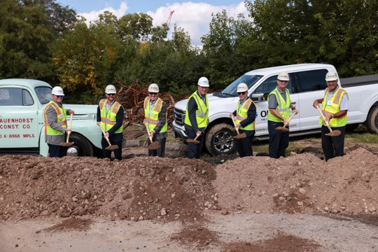 men wearing safety vest and hardhats using shovels to dig