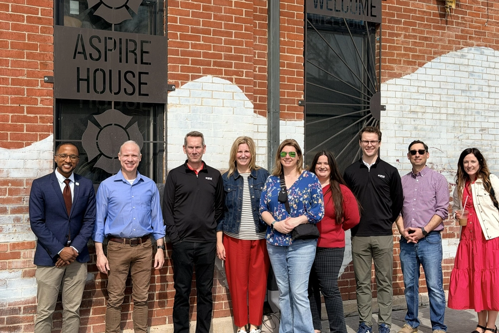 group of men and women standing in front of building