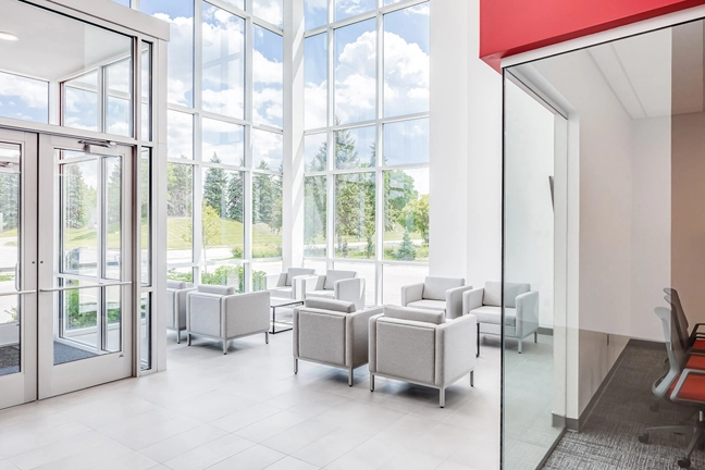 seating area in lobby with rows of chairs and floor to ceiling windows