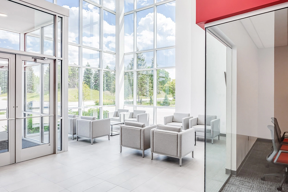 seating area in lobby with rows of chairs and floor to ceiling windows