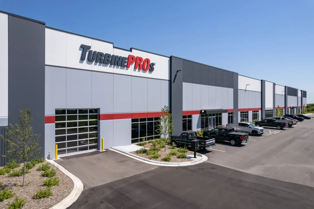 exterior of industrial building's dock doors with sign reading "TurbinePROs" on building