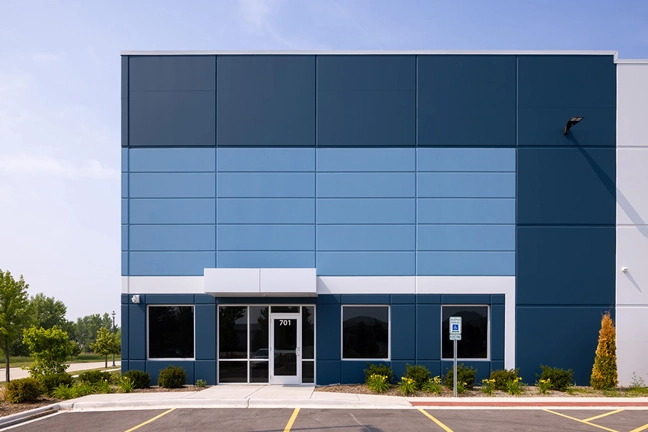 exterior of industrial building entrance with parking lot in foreground