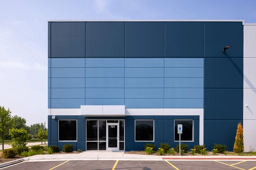 exterior of industrial building entrance with parking lot in foreground