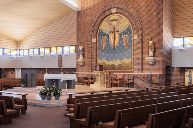 church sanctuary with rows of pews in foreground and altar area in background