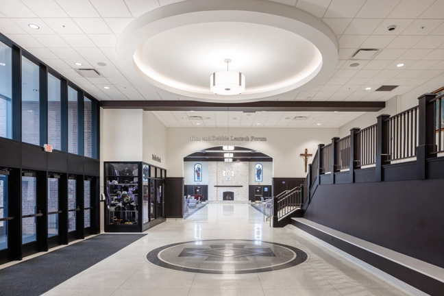 lobby of institutional building with dark wood and white walls, ceiling and floor
