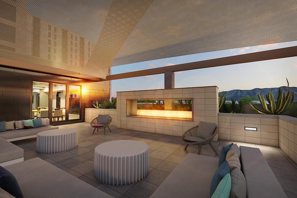 rendering of covered outdoor living area of a residential building showing couches and chairs facing fireplace and planters along rooftop at sunset