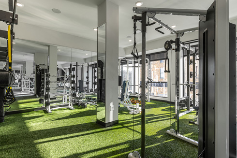 fitness center in an apartment building with weightlifting machines and barbells