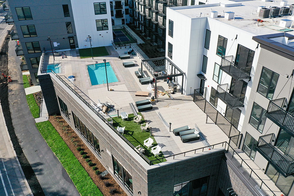 aerial view of an apartment building's rooftop outdoor amenity area including pool