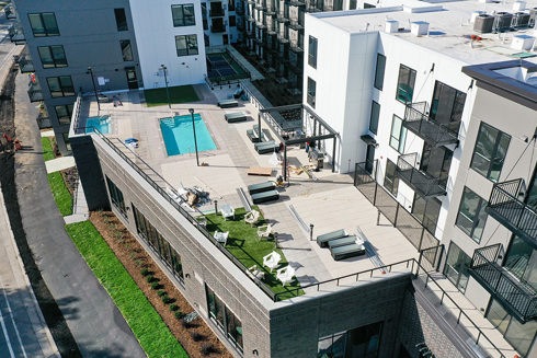aerial view of an apartment building's rooftop outdoor amenity area including pool