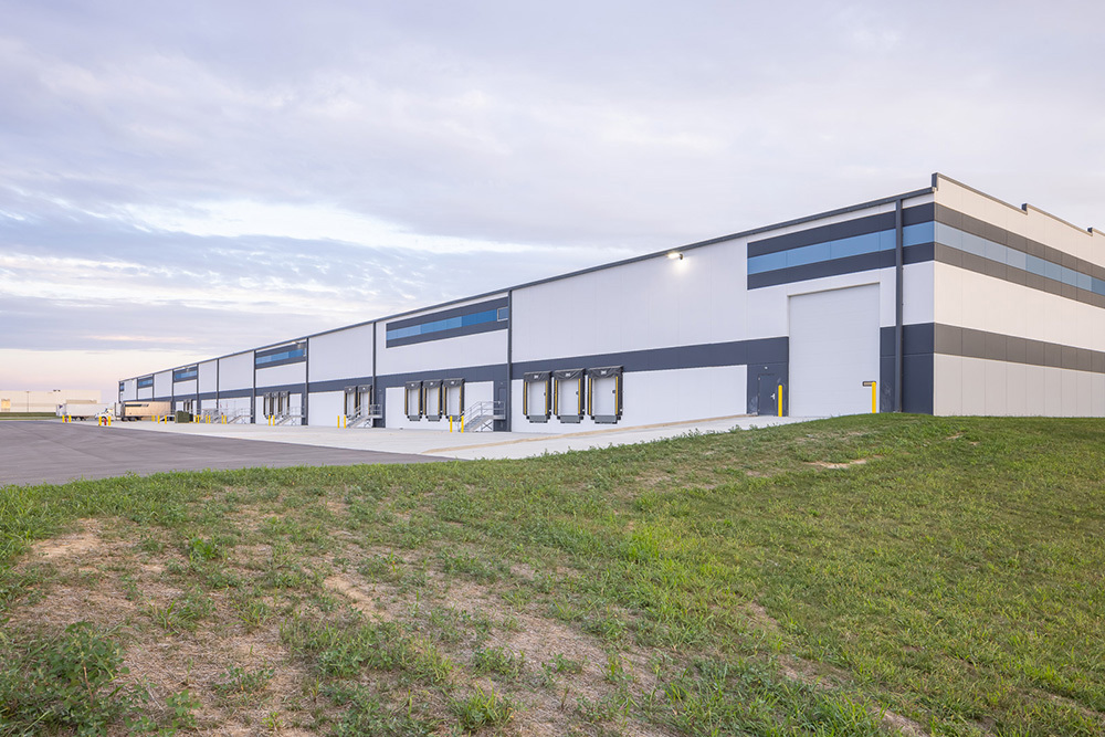 Rear of a multi-tenant speculative industrial building with a drive-in door and dock doors