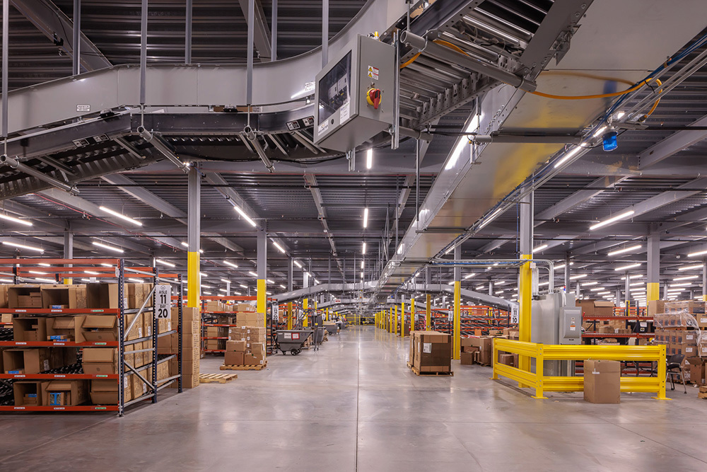 warehouse in an industrial building with rows of short shelving filled with boxes