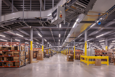warehouse in an industrial building with rows of short shelving filled with boxes