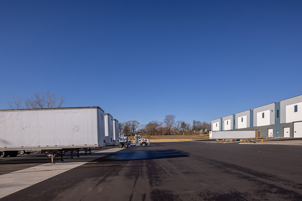 Back of a speculative industrial building with dock doors and truck trailers