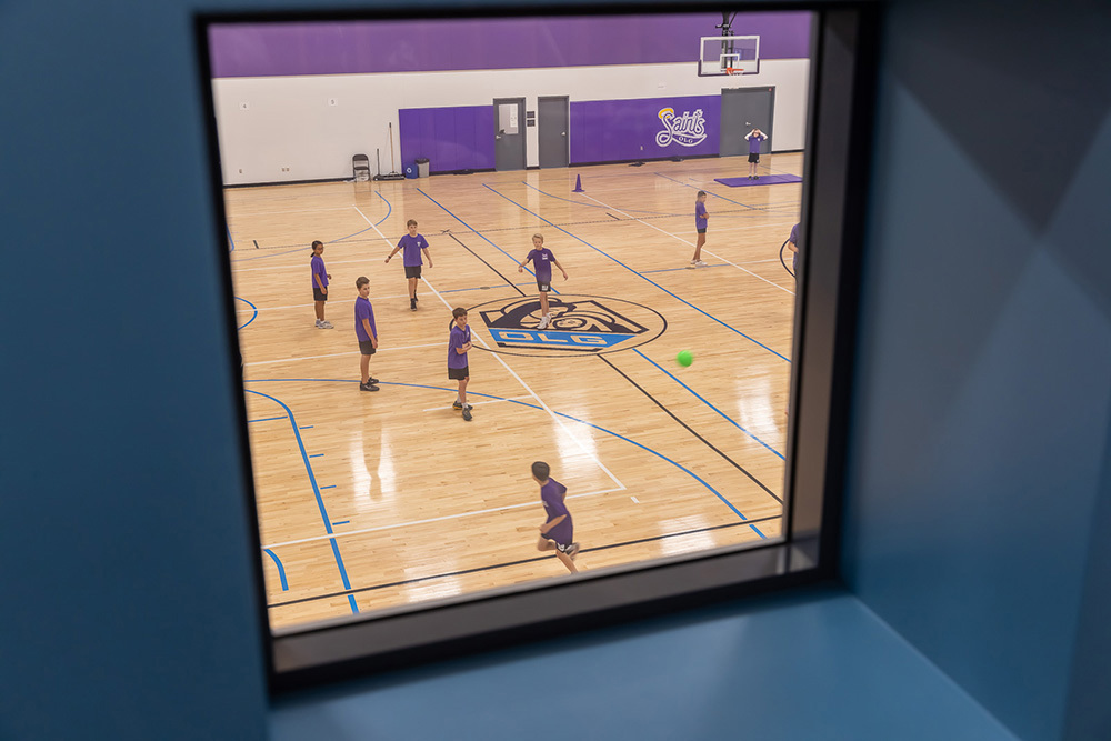 view of gym through an upstairs window in an institutional building