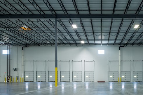 interior view of empty warehouse with dock doors in the background