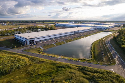 aerial view of industrial buildings with retaining pond in foreground