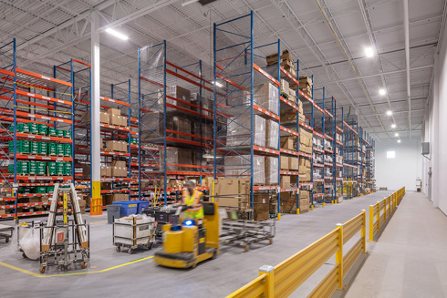 warehouse in an industrial building with tall shelves filled with boxes