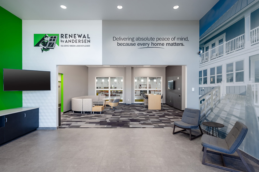 lobby of an industrial building with seating areas and words "Renewal by Andersen" on wall