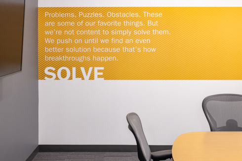 conference room in the office space of an industrial building with a yellow band on the wall with words
