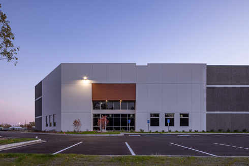 Front view of an industrial building showing an entrance at dusk