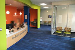 lobby of a healthcare building with the reception desk on the left and seating area on the right