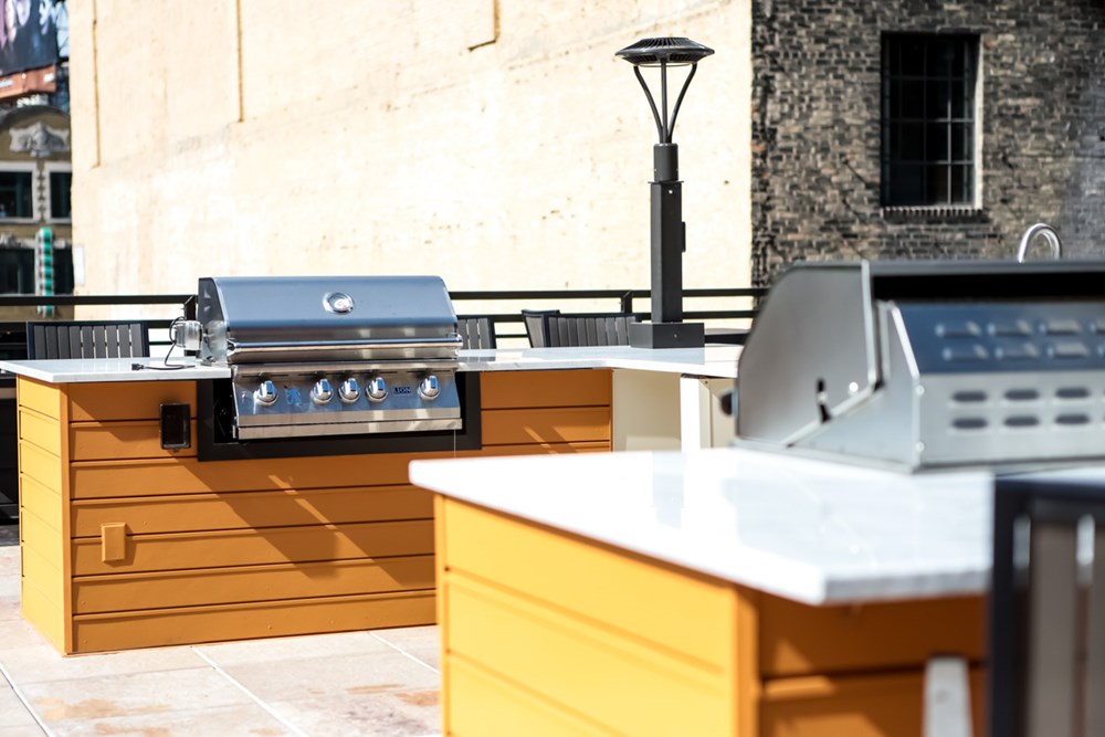 grills with countertops in the outdoor living area of an apartment building